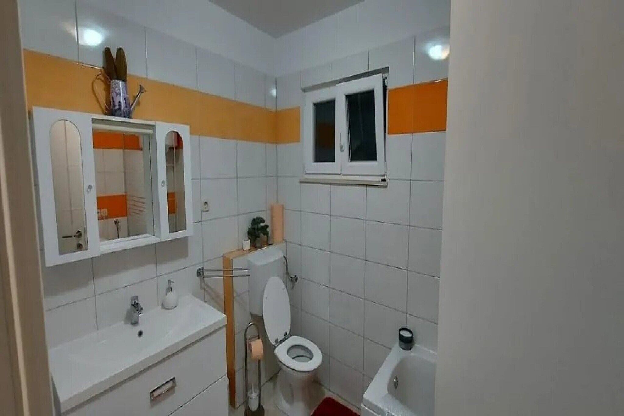 Ein Badezimmer mit Toilette, Waschbecken und Spiegel.