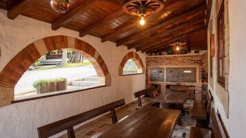 Un interior con bancos de madera, arcos de ladrillo y una chimenea de ladrillo.