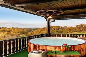 Ein hölzernes Whirlpool mit Blick auf eine bewaldete Landschaft.