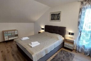 A bedroom with a large bed, two bedside tables, a nightstand, a wall-mounted picture, and a window with curtains. - Villa Tamaris - Two Bedroom Holiday Home with Terrace and Swimming pool (Mali Drvenik)