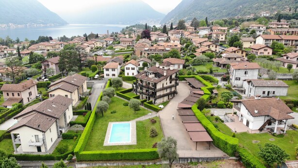 A residential area with houses, a swimming pool, and a view of a lake.