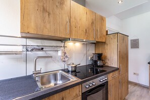 Una cocina moderna con armarios de madera, electrodomésticos de acero inoxidable y salpicadero de mármol.