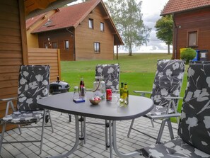 A patio with a table and chairs, a grill, and a view of houses in the background. - Holiday Home 'Hexenpfad' with Private Terrace, Private Garden and Wi-Fi (Hasselfelde)