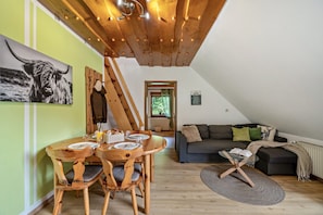 Un coin repas avec une table et des chaises en bois, un canapé et une petite table basse.