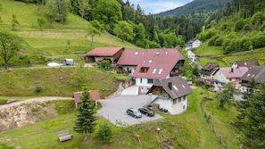 Un village perché sur une colline, avec des maisons traditionnelles, une allée de gravier et un petit banc.