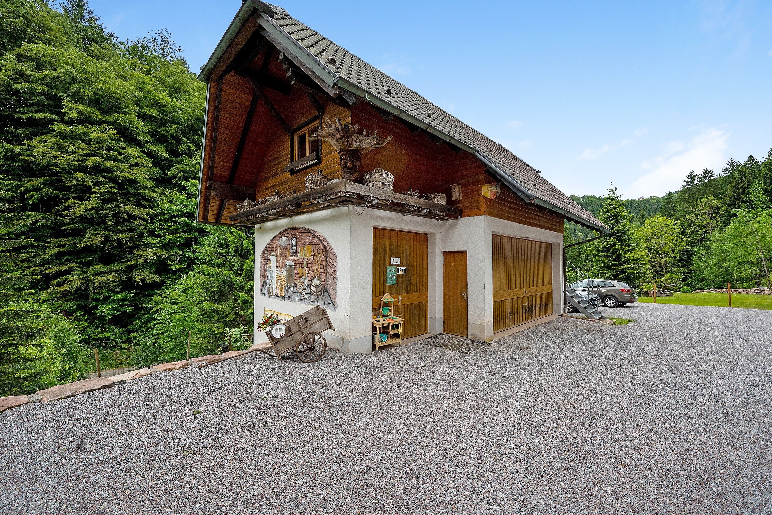 Un bâtiment en bois avec un toit en pente, un petit porche et une allée gravillonnée.