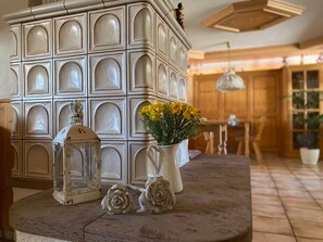 Un'area pranzo con un ampio mobile bianco, un tavolo con un vaso di fiori gialli e due rose decorative.