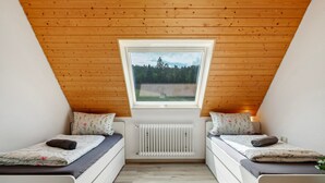 A room with two beds, a window, and a radiator. - Apartment 'Ringwald' with Mountain View, Shared Garden and Wi-Fi (Biederbach)