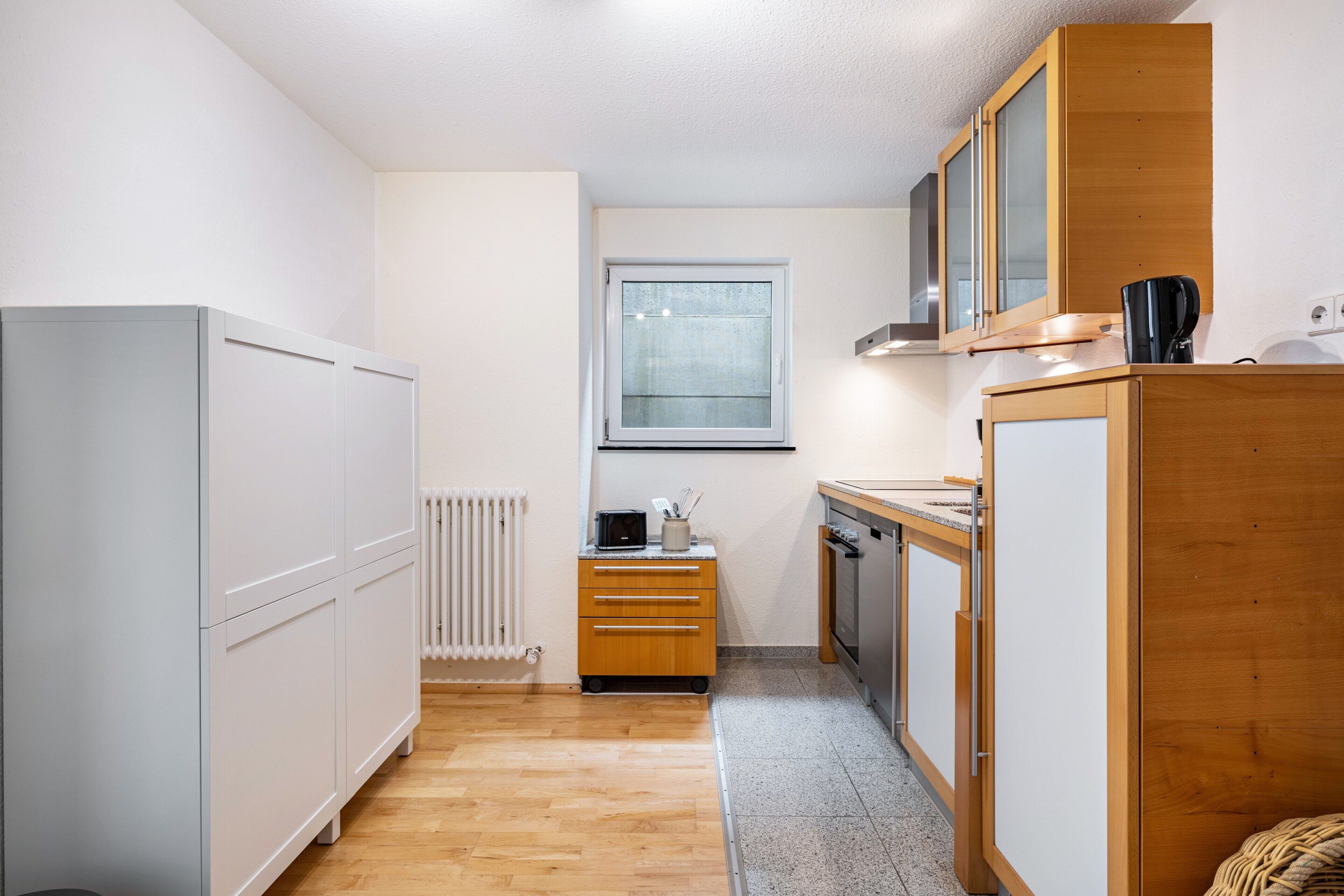Una cucina compatta con frigorifero, fornello e mobili in legno.