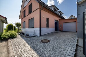 Une maison à deux étages avec une allée pavée et un garage.