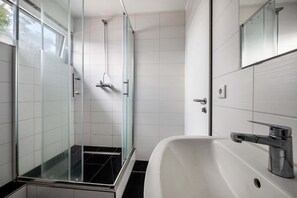 Een douche, handdoeken, toiletpapier