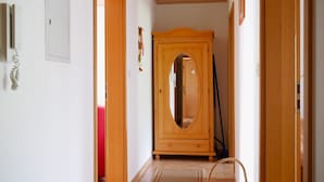 A hallway with a wooden wardrobe, a telephone, and a red chair. - Apartment 'Nr 2' with Shared Garden, Balcony and Wi-Fi (Bad Peterstal-Griesbach)