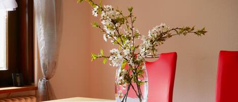 A clear glass vase with white flowers on a table.