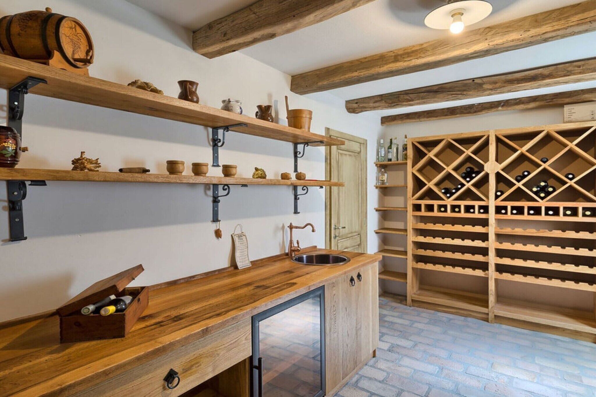 Una cocina con estantes de madera, un botellero y una encimera de madera.