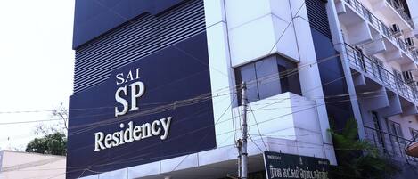 A multi-story building with a sign for SAI SP Residency.