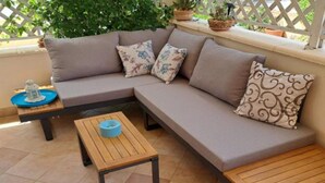 A sectional sofa with floral cushions, a small wooden table, and a blue bowl.