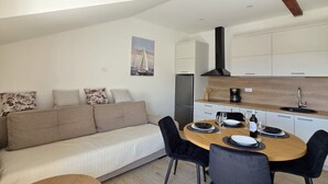 Een moderne keuken met witte kasten, een houten aanrecht en een inbouwoven.