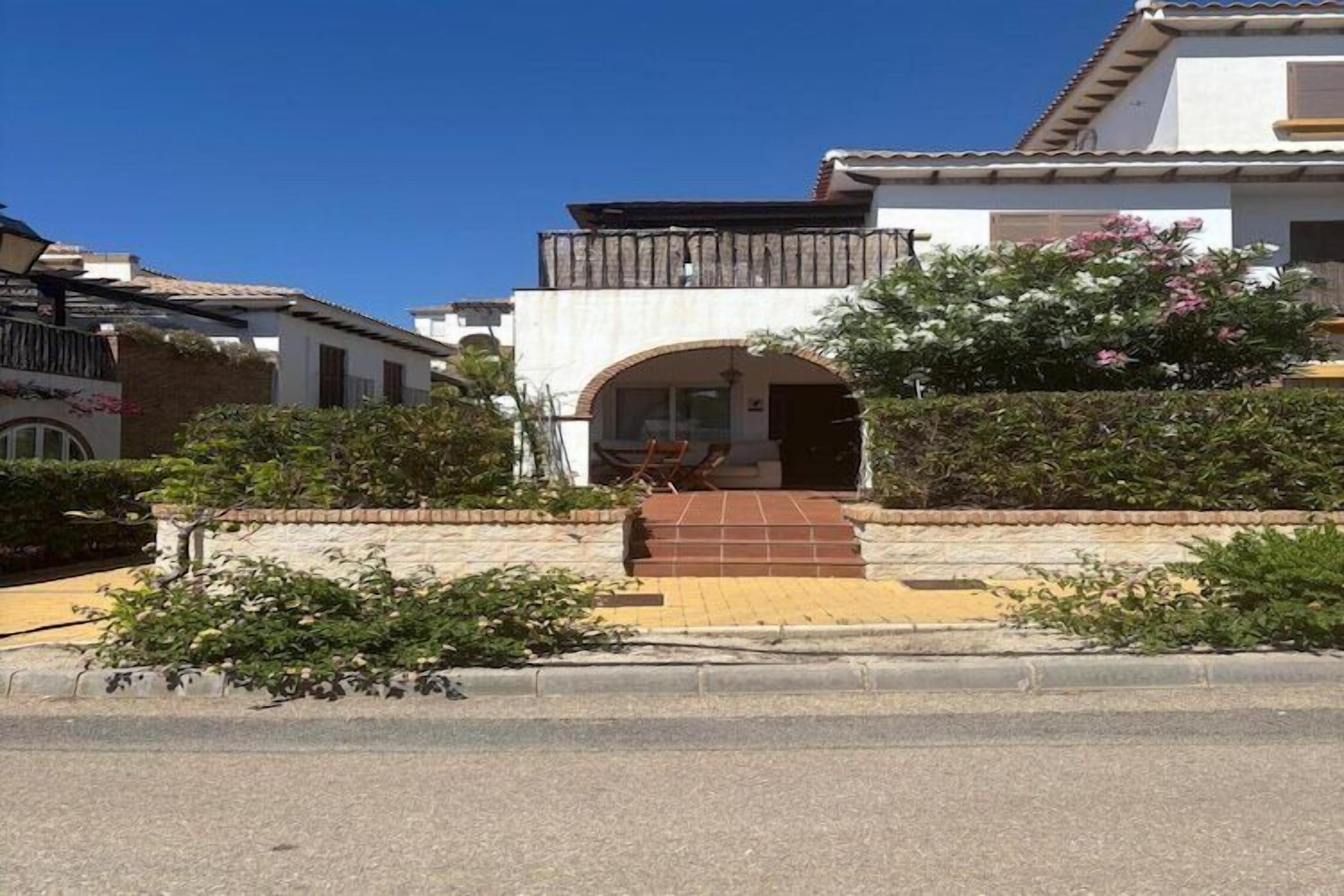 Une maison à deux étages dotée d’un balcon, d’un hall d’entrée carrelé et d’un jardin.