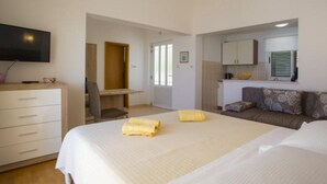 A hotel room with a bed, a desk, a chair, a sofa, and a television. - Sea View Apartments Lendic Podgora - Classic Studio Apartment with Terrace and Sea View (Podgora)