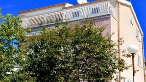 A building with a balcony, satellite dish, and a street lamp. - Apartment Belu - Two Bedroom Apartment With Sea View (Brodarica)