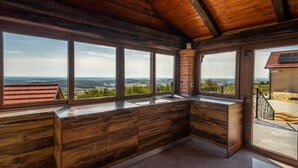 A kitchen with large windows, wooden cabinets, and a view of the countryside. - Villa Breg - Four Bedroom Villa with Pool, Hot-Tub and Sauna (Križevci)