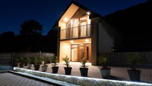 A two-story house with a balcony, potted plants, and a stone pathway. - Villa Breg - Four Bedroom Villa with Pool, Hot-Tub and Sauna (Križevci)