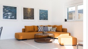 A modern living room with a mustard-colored sofa, a round coffee table, and three framed artworks on the wall. - Luxury Villas Bellavista - Four Bedroom Villa with Pool (Pag)