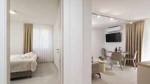 Ein modernes Hotelzimmer mit Bett, Schreibtisch und Essbereich.