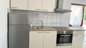 A modern kitchen with white cabinets, a stainless steel refrigerator, a sink, a stove, and an oven. - One Bedroom Apartment with Balcony (3) (Biograd na Moru)