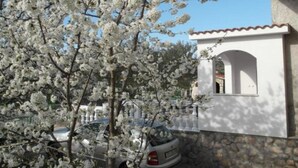 A car parked in front of a building with a stone wall and a white fence. - One Bedroom apartment with Terrace (Šibenik)