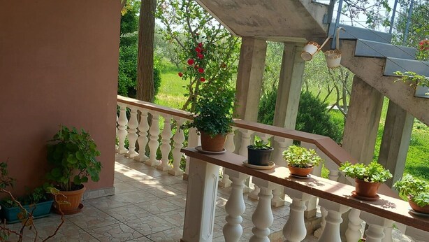 A balcony with a railing, potted plants, and a view of greenery. - Apartments Rubbi - Three Bedroom Apartment with Terrace (Vrsi)