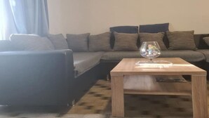 A living room with a sofa, a coffee table, and a window with curtains. - Apartments Rubbi - Three Bedroom Apartment with Terrace (Vrsi)