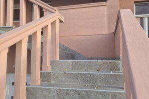 A staircase with pink railings and stone steps.