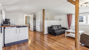 A compact living space with a kitchenette, a sofa, and a dining area.