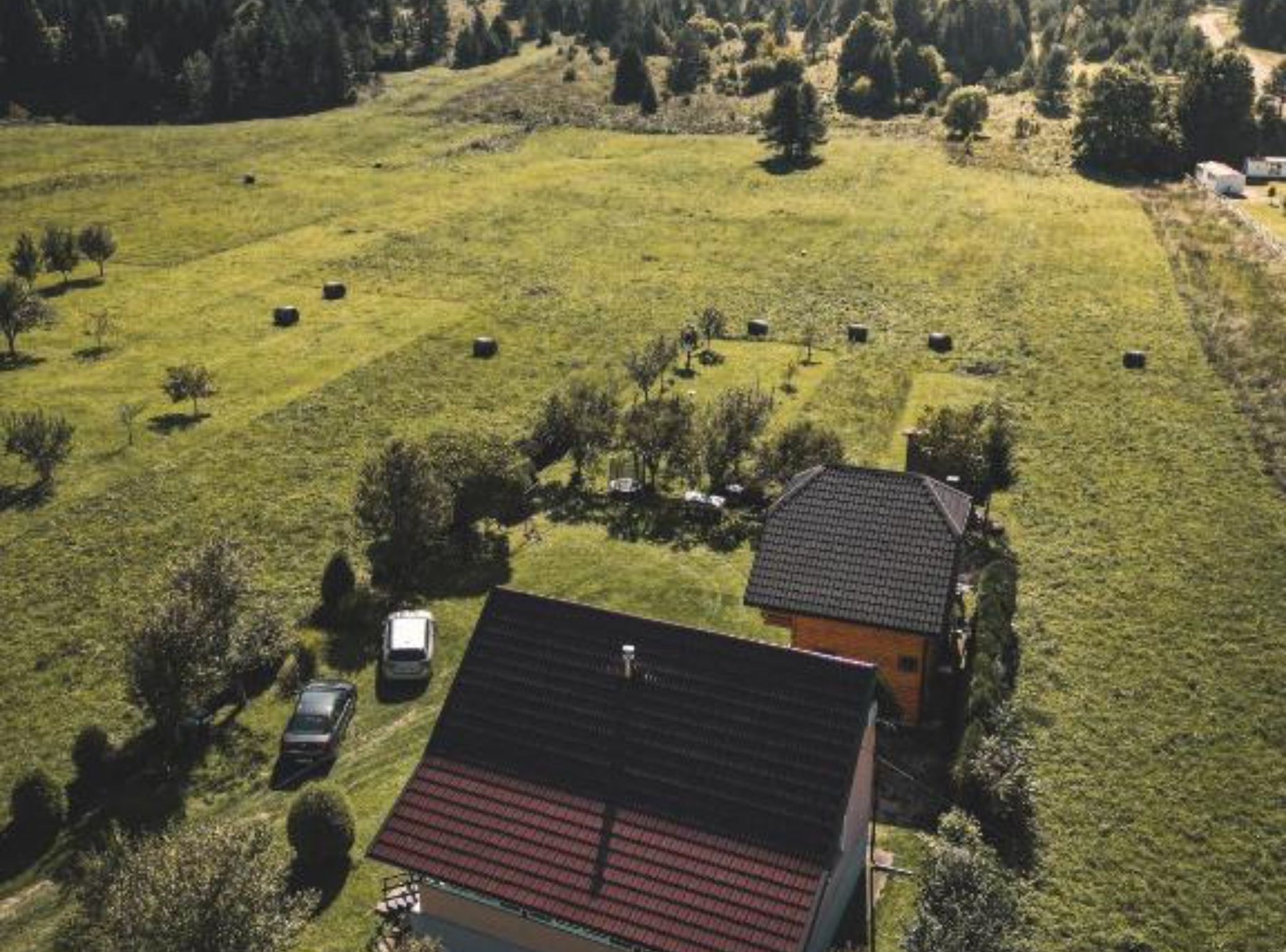 An aerial view of a rural property with a house, barns, and grazing fields.