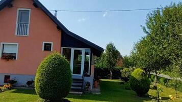 Een huis met een schuin dak, een veranda en een verzorgd gazon.