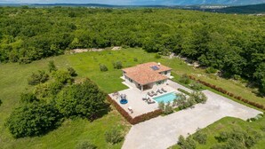 A house with a swimming pool, surrounded by lush greenery and mountains in the background. - Holiday Home Milevoj - Three Bedroom Holiday Home (Labin)