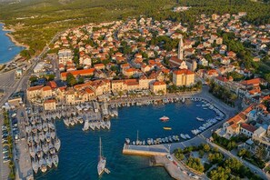 An aerial view of a coastal town with a marina filled with boats, surrounded by residential buildings and a prominent church. - Apartment MARIJANA - Two bedroom Apartment with Terrace (Supetar)