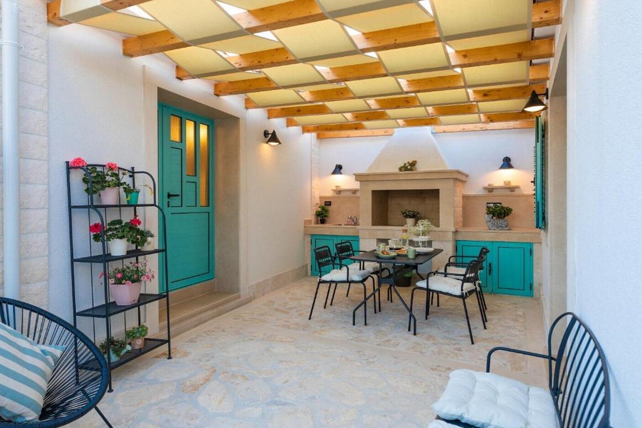 Un patio acogedor con mesa y sillas, una chimenea y una puerta verde.