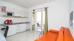 A modern kitchen with white cabinets, a microwave, and a coffee maker.