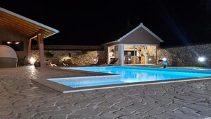 A swimming pool with a stone patio, a covered seating area, and a stone wall. - Villa Nika - Three Bedroom Villa with Private Pool (Lozovac)