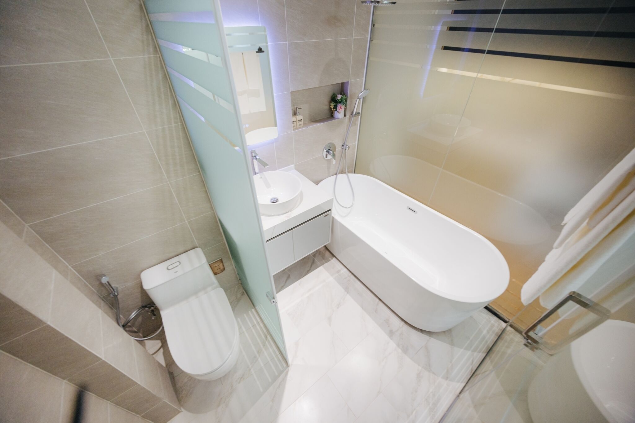 A modern bathroom with a bathtub, a toilet, and a sink.