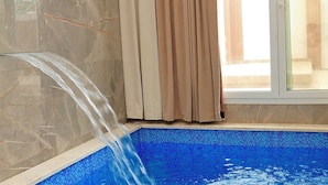 A swimming pool with clear water, a tiled wall, and a window with curtains. - Dreamland Resort Salalah (Salalah)