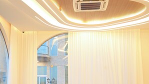 A modern interior with a sofa set, a coffee table, and a large window with curtains. - Dreamland Resort Salalah (Salalah)