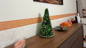 A room with a wooden desk, a small Christmas tree, a framed picture of the Colosseum, and a pink candle. - Sun & Sea 2 steps from Rome (Fiumicino)