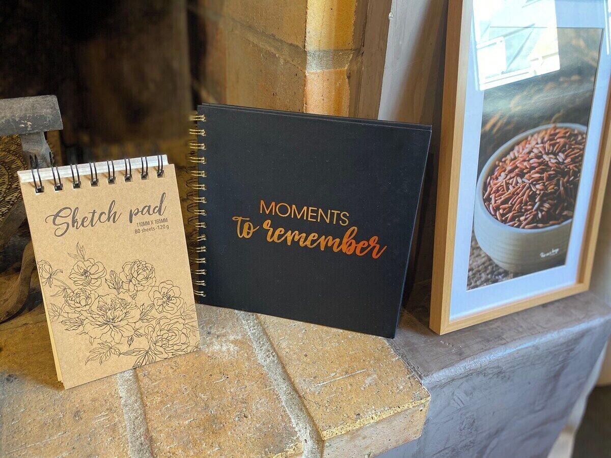 Un carnet de croquis et une photo encadrée posés sur la cheminée.