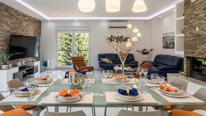 Een moderne eetruimte met een glazen tafel voor zes personen, omringd door comfortabele zitplaatsen.