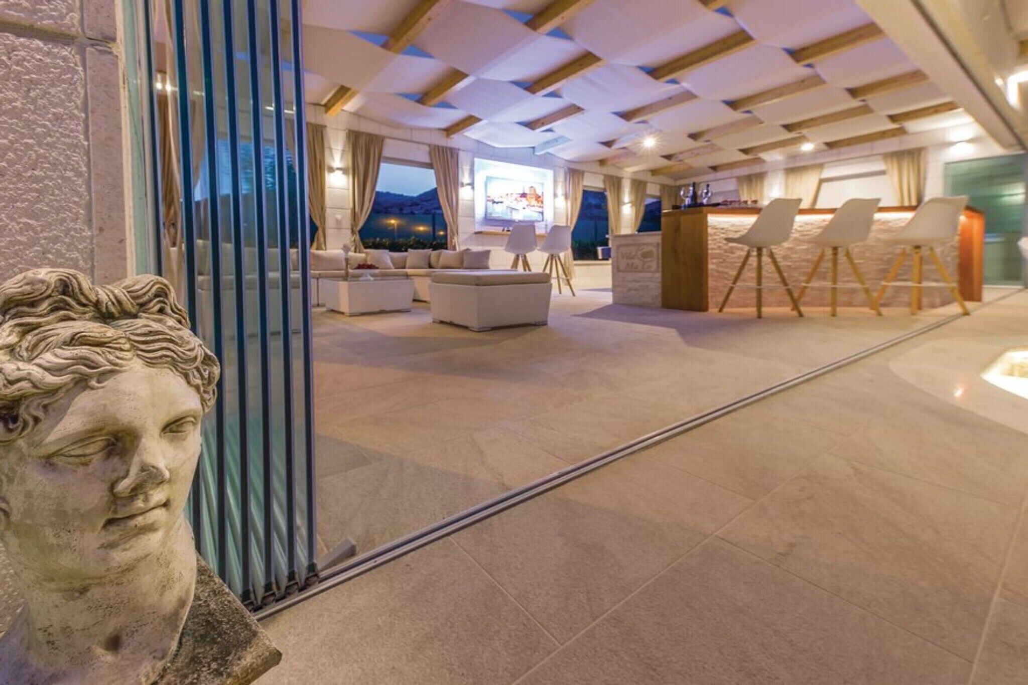 Een moderne hotellobby met een zithoek, een receptiebalie en een groot raam met uitzicht op het omliggende landschap.