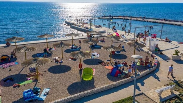 A beachside area with umbrellas, sun loungers, and a pool. - Two Bedroom Apartment With Private Pool (Privlaka)