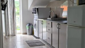 Una cuina moderna amb electrodomèstics d'acer inoxidable, forn integrat i un lavabo.